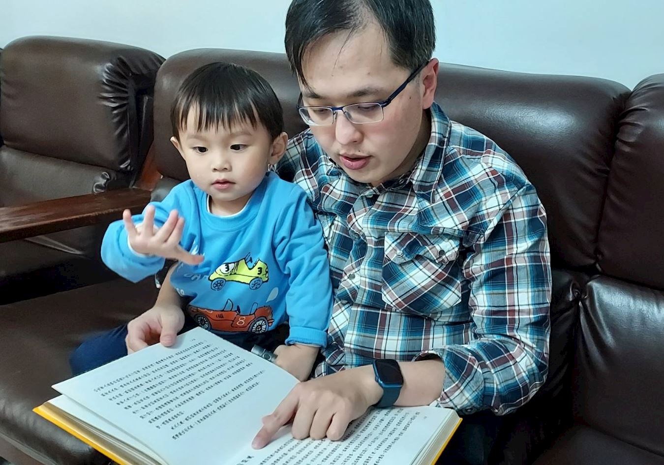 '图2:唯同带着孩子一起阅读《转法轮》。'