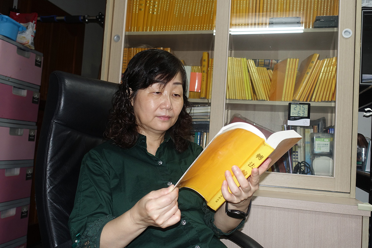 图1:许美惠在家中阅读《转法轮》。