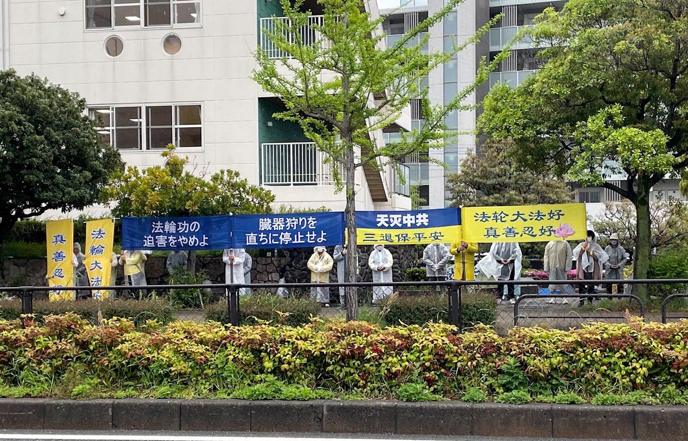 '图7:中领馆前,福冈学员在雨中举行纪念活动。'