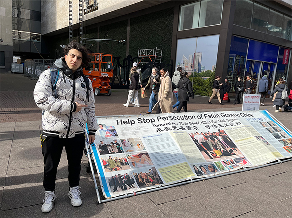 图12:软件开发专业学生雷扎·卡扎伊( Reza Khazaei )停下来了解更多有关功法和迫害的信息。