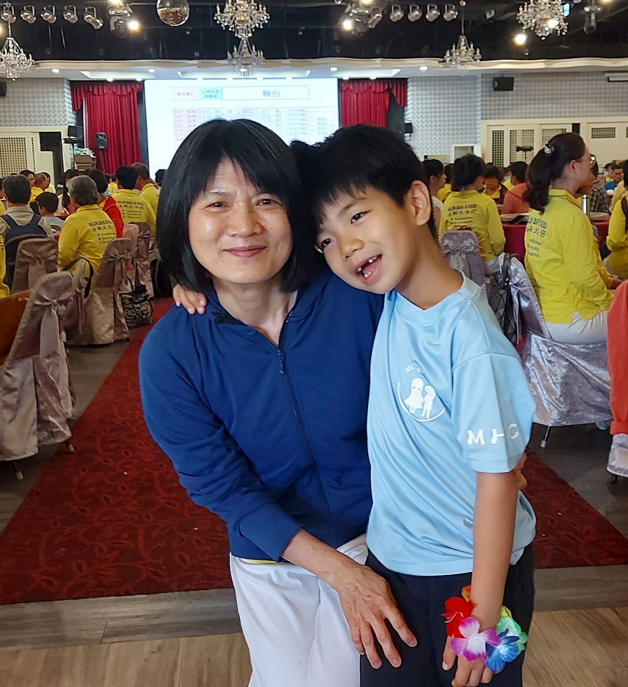 '图9:汤淑铃与孙子一起参加庆祝活动。'