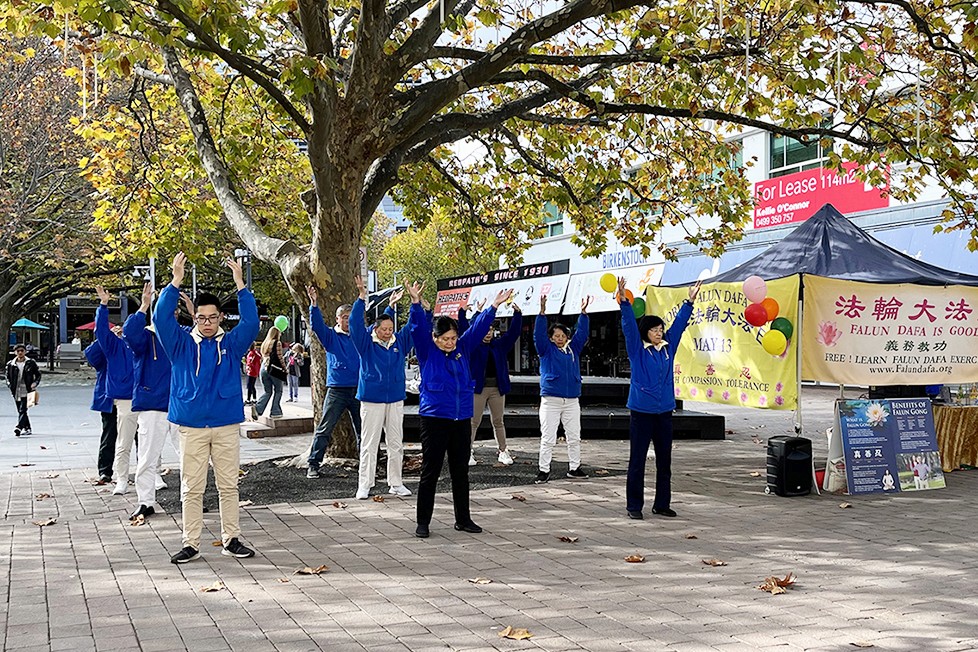 图1:法轮功学员向市民们展示法轮功五套功法。