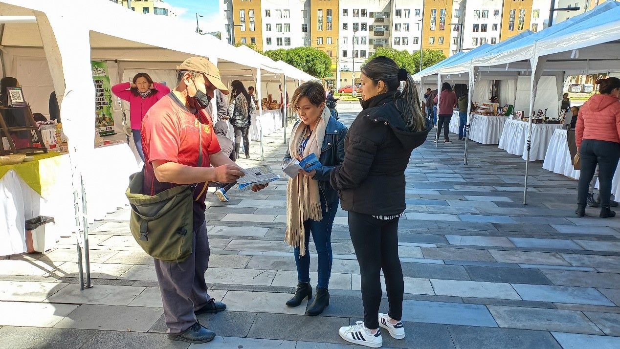 图8:五月十日一位摊主在首都基多闹市(卡拉罗娜公园北部)帮法轮功学员分发传单