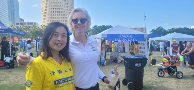 '图2:坦帕市长珍妮。凯斯特接受莲花并和学员合影'