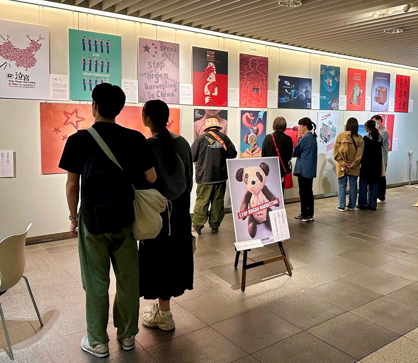 '图1~3:二零二三年五月十八日至二十一日,在北海道首府札幌市中心的札幌站前地下广场(chikaho)举办“制止中共活摘器官入选海报作品展”,许多市民停下脚步认真观赏每幅作品,签名呼吁制止活摘器官。'