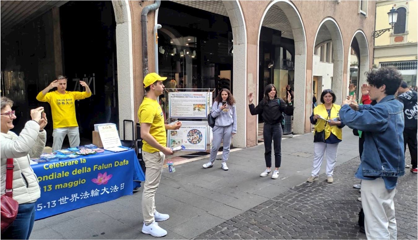 '图6:庆祝大法弘传三十一周年,帕多瓦(Padua)法轮功学员设立了真相点,向人们传播法轮大法的美好及其真相。看到学员展示功法的祥和场面,一些学生也跟着学炼。'