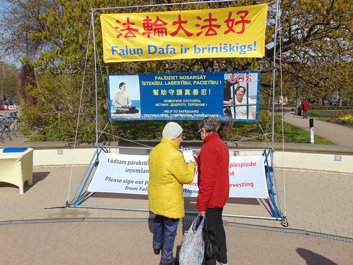 图1~2:在拉脱维亚港口城市利耶帕亚的玫瑰广场,民众前来了解法轮大法及中共迫害法轮功的真相。