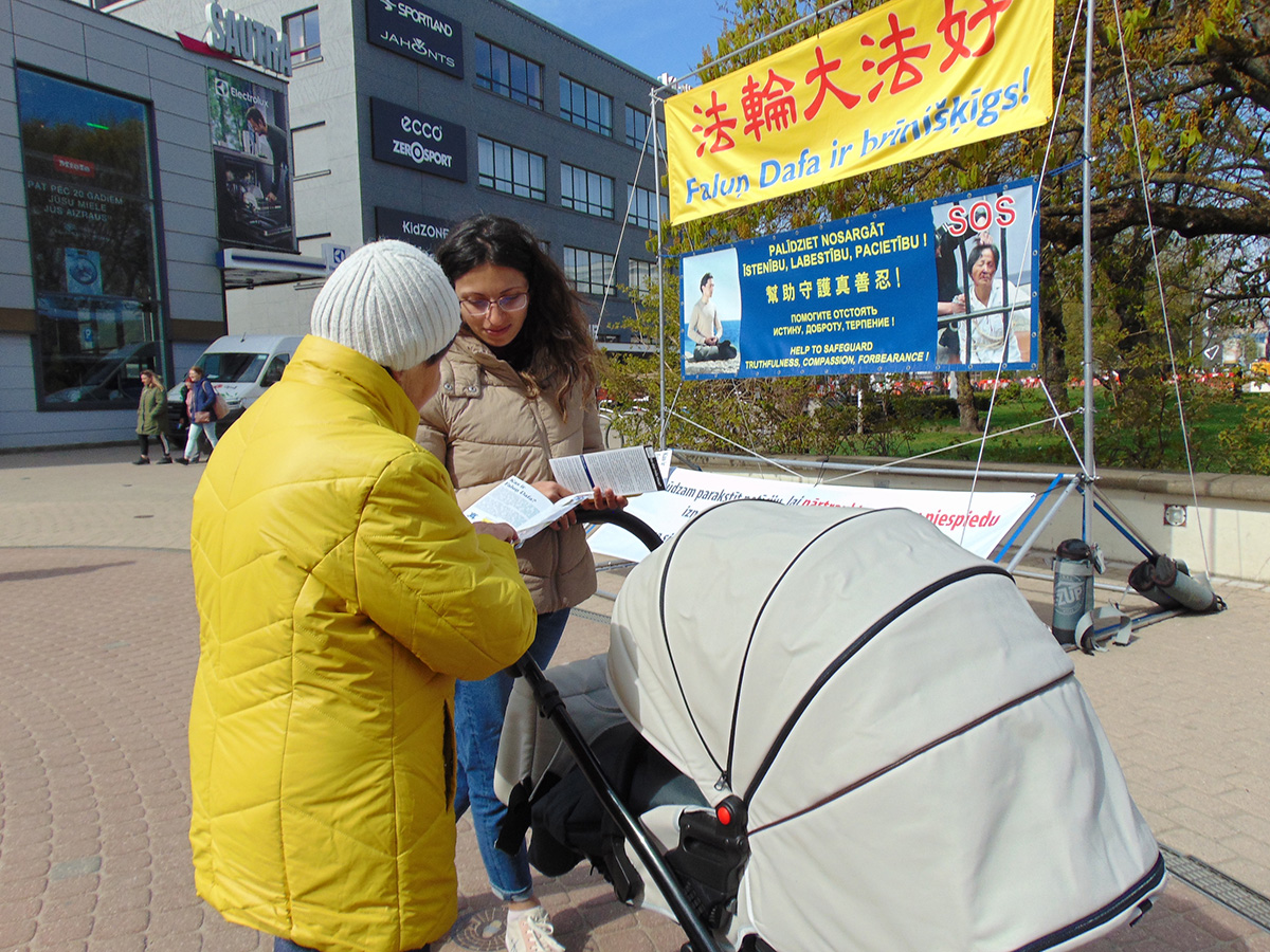 图7:一位女士对法轮功学员说:“我希望我的签名会有所帮助。”