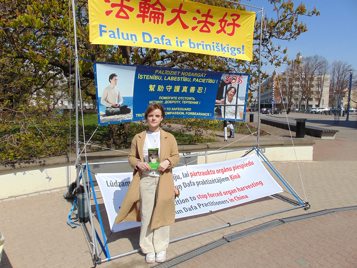 图8:一位年轻女孩在反迫害征签表上签名,呼吁制止中共暴行。