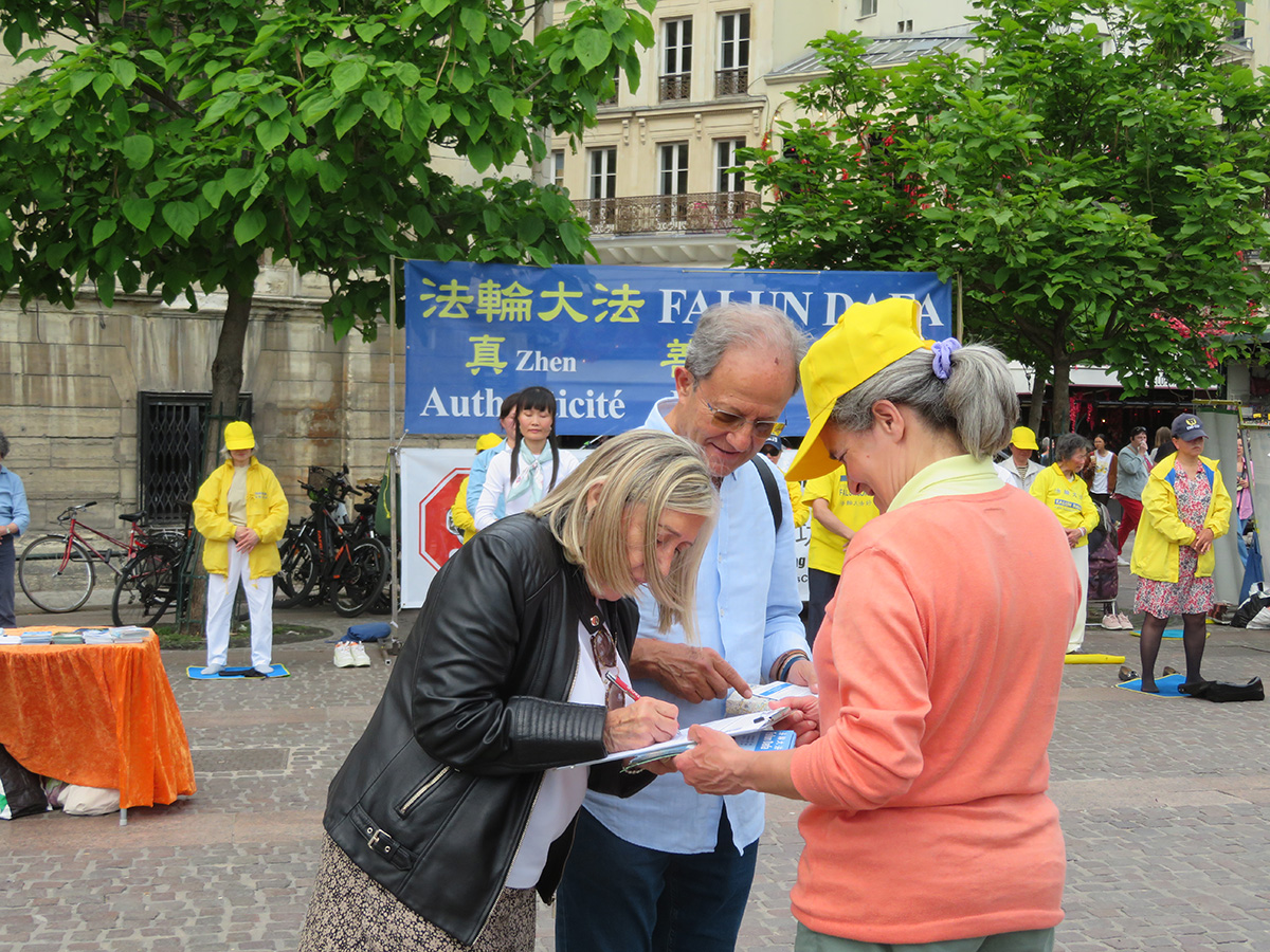 图4~5:在夏特雷(Châtelet)街区的真相点,人们签字支持法轮功学员反迫害。