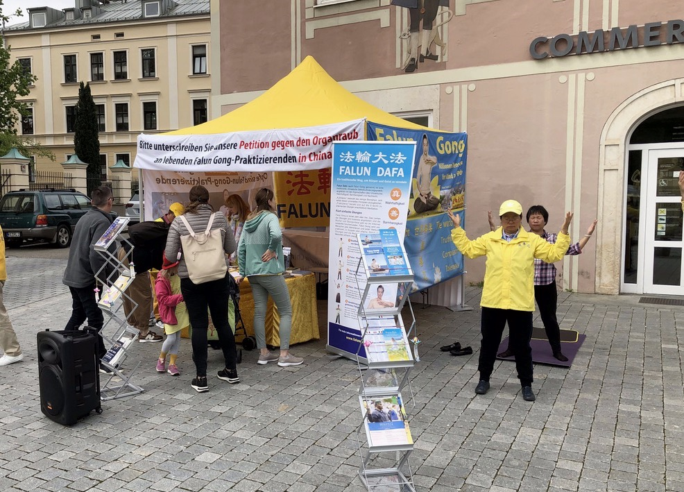 图3:二零二三年五月二十日,法轮功学员在肯普腾市政厅前举办的讲真相活动,吸引过往路人驻足了解。