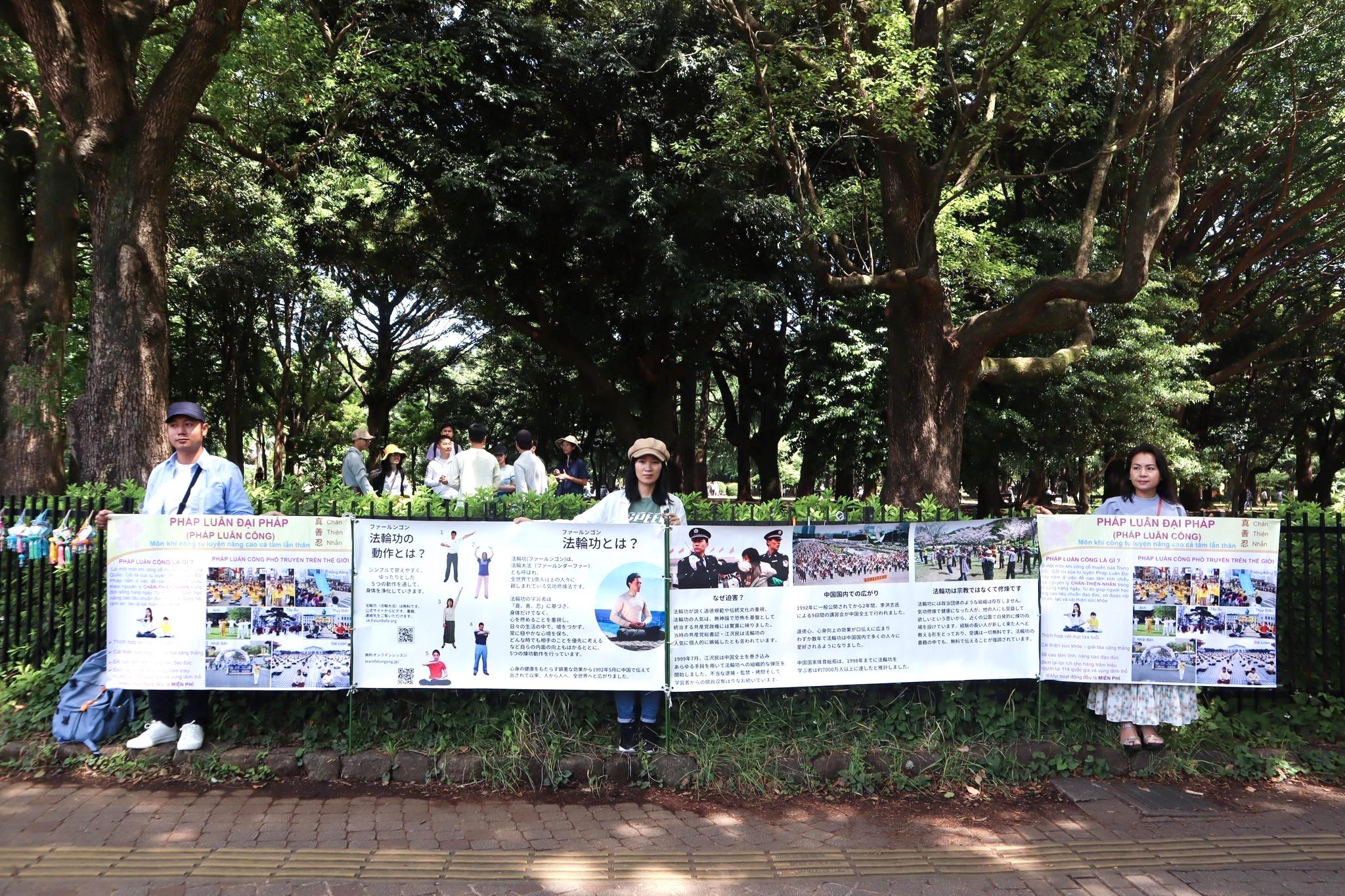 图1:法轮功学员打出日语和越南语的法轮功简介展板,方便人们了解法轮大法。