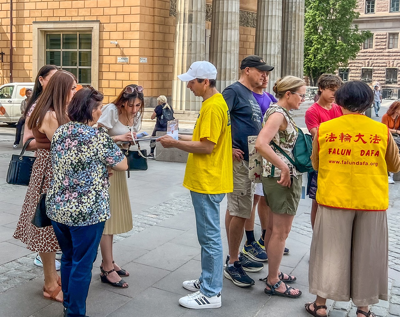 图5:二零二三年六月十七日,法轮功学员在斯德哥尔摩皇宫旁的钱币广场举办讲真相活动,学员在征集反迫害签名。
