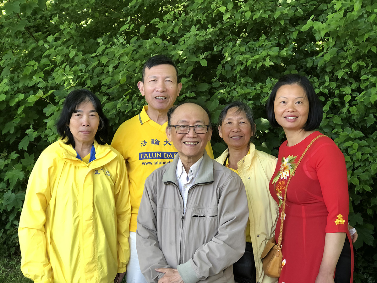 图10:阮先生(中)和几位越南裔的法轮功学员一起来参加活动。
