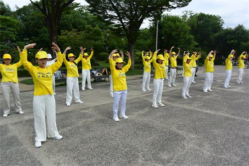 '图5~6:法轮功学员在大阪城公园的天守阁下集体炼功'
