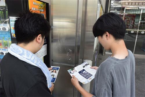 '图11:阅读法轮功资料的佐藤先生(右)和大道先生(左)'