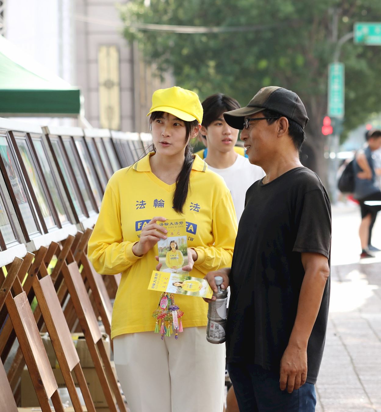 '图16:学员为过往路人解说法轮功弘传世界的图片展。'