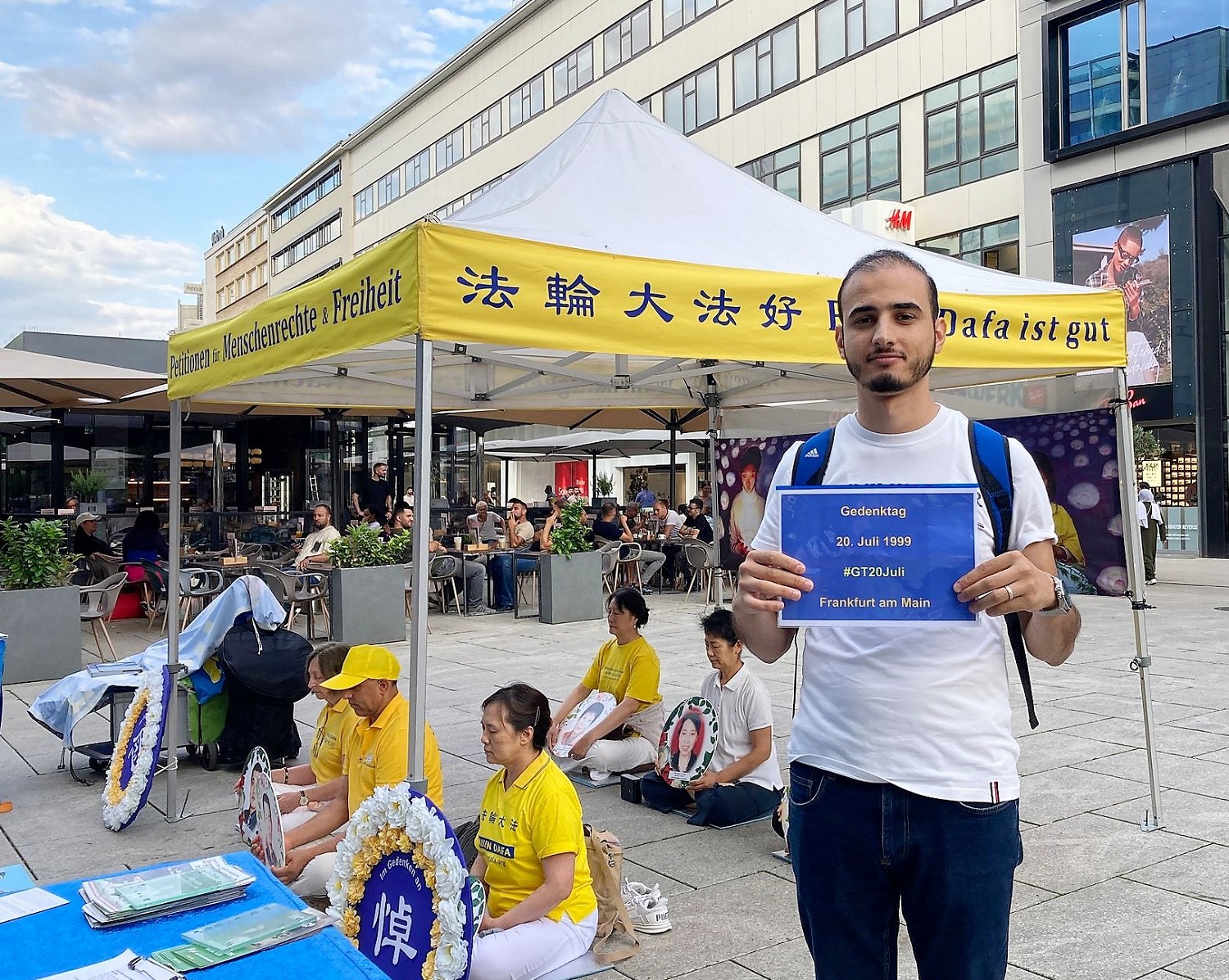 图6~8:在法兰克福的市中心,多位民众了解真相后举起了“悼念七‧二零”的标语牌拍照,支持法轮功学员反迫害