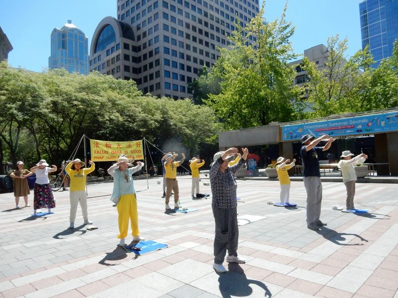 图1:二零二三年七月十五日,反迫害24周年。西雅图部份法轮功学员在市中心举行集会。学员平静祥和的五套功法,向民众传递真相。