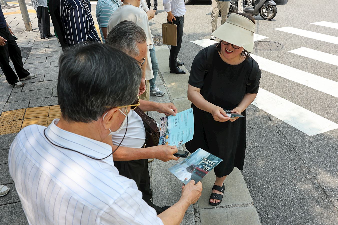 '图23:市民阅读传单,了解法轮功被迫害真相。'