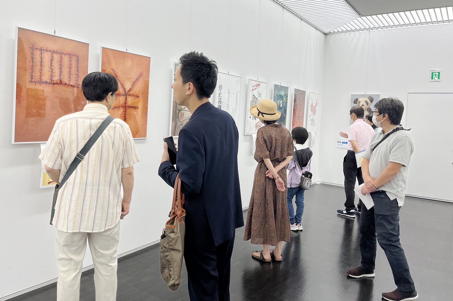 图1:二零二三年七月二十五日,制止中共活摘器官国际获奖作品海报展在日本广岛县东广岛市立美术馆举行。图为参观者认真观看展览作品,了解活摘真相。