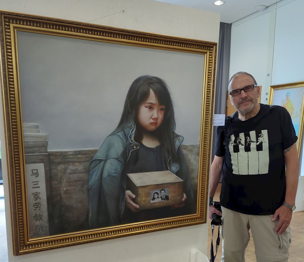 '图6:一位退休的专业摄影师观看画作《孤儿泪》很受触动,他在留言簿上写道:“感谢你们举办了一场感人至深、发人深省的展览。”'