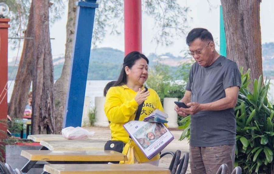 '图3:学员向游人讲解法轮大法的真相以及在中国正在发生的迫害。'