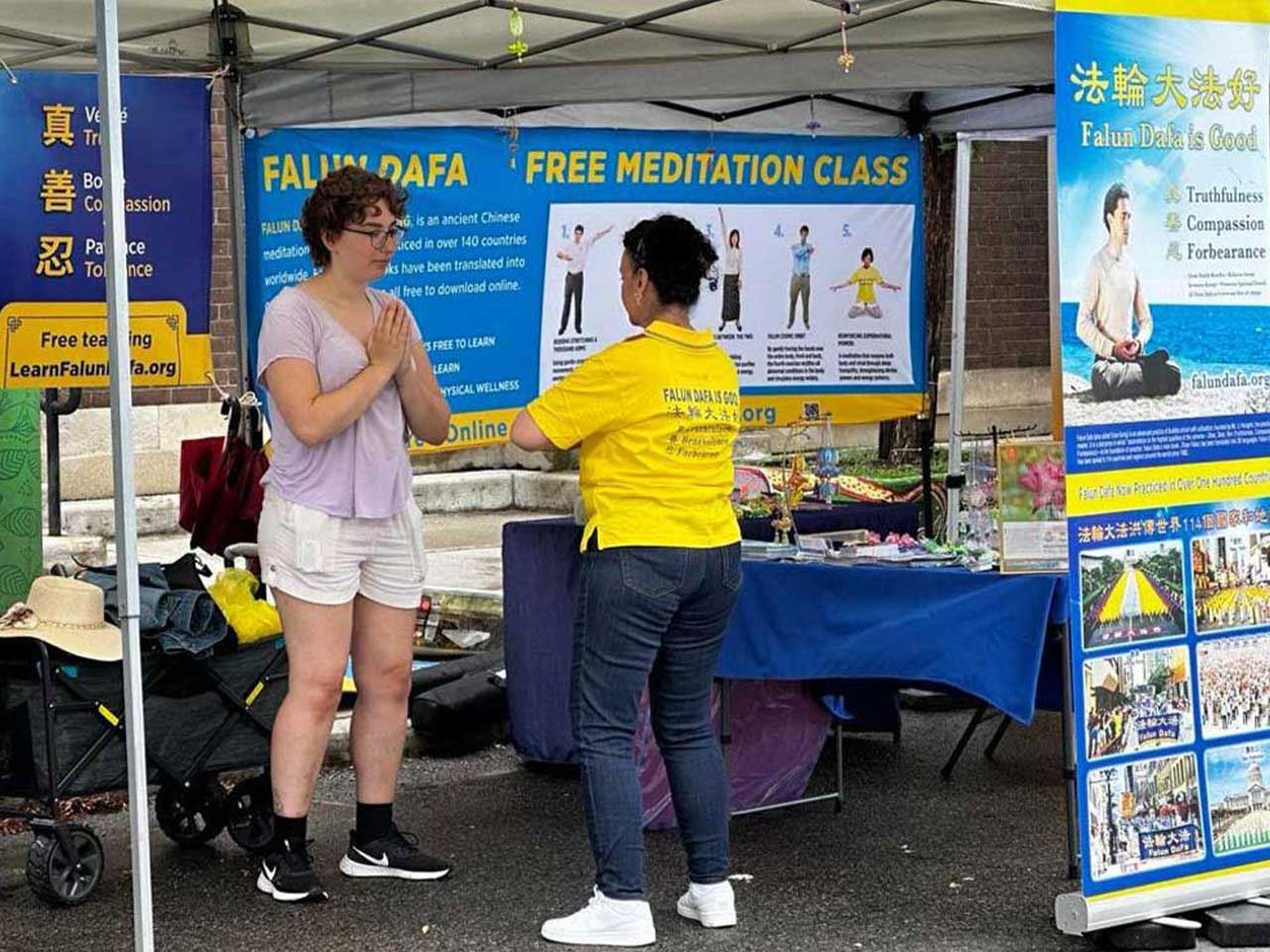 '图5~8:人们在法轮大法展位学炼功法'