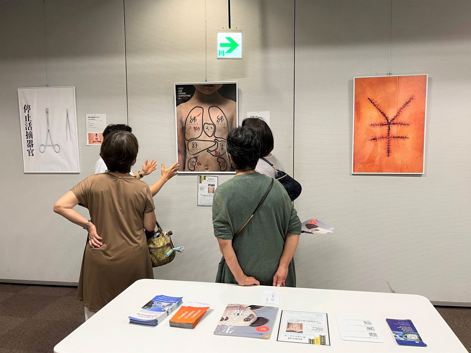 图1:制止中共活摘器官国际获奖作品海报展现场解说员在给观众讲解作品的含义。