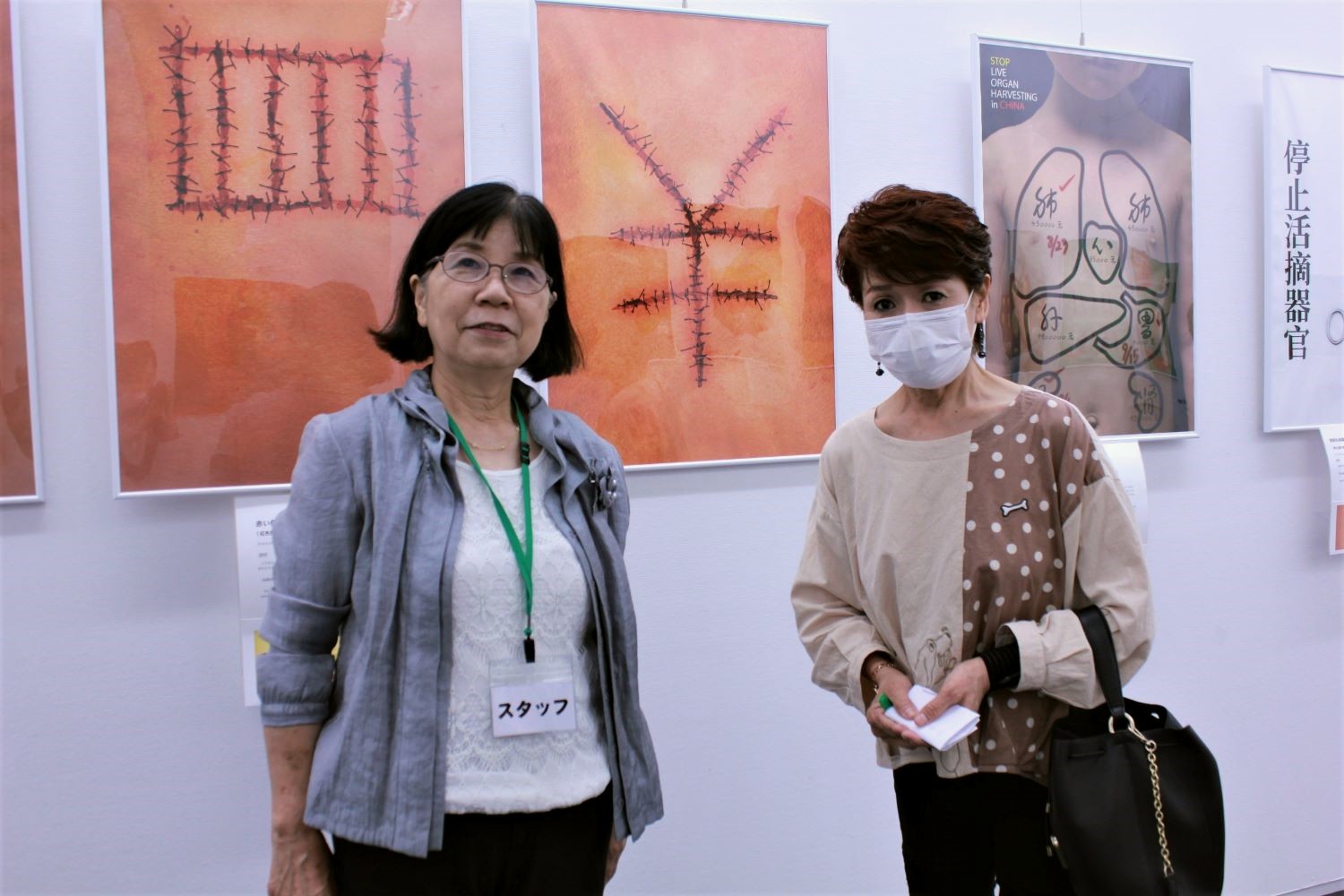 图2:六十多岁的女士(右)说看过海报展之后,自己的想法变了。