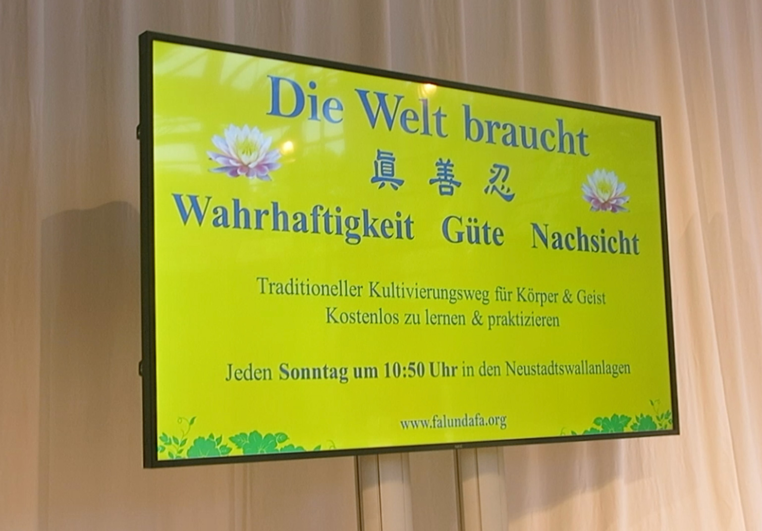 图3:博览会的屏幕上显示着“世界需要真、善、忍”以及不来梅学法小组的炼功时间和地点。