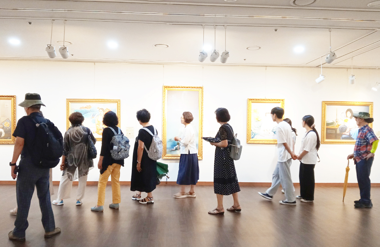 图2:观众们在观看“真善忍国际美术展”作品