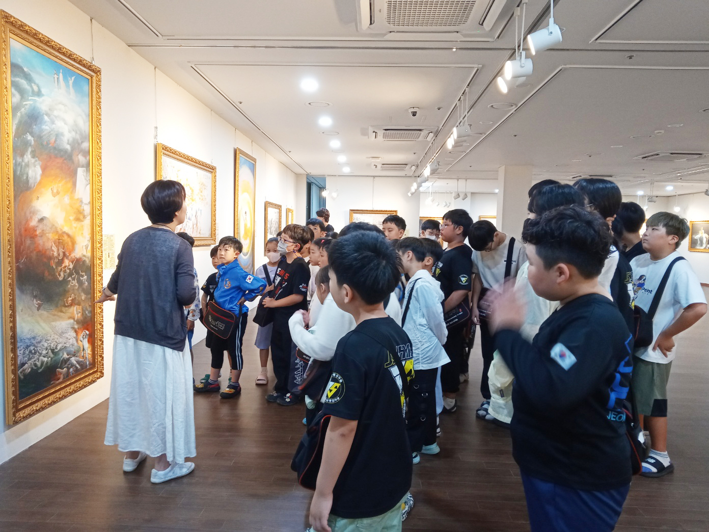 图4:认真听真善忍美展作品说明的补习班学生们。