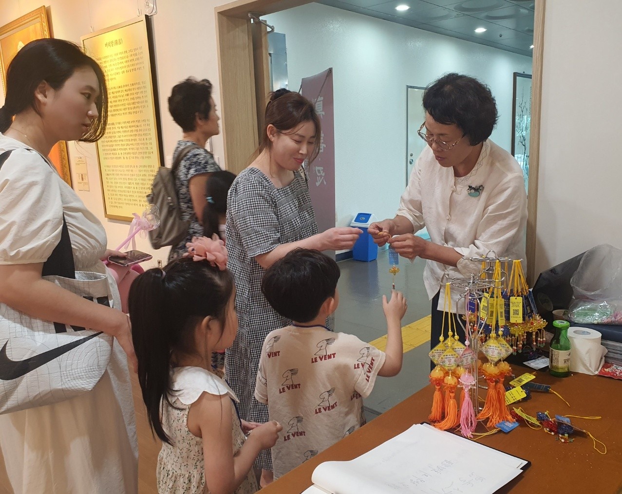图6:观看画展的人们收到九字真言书签和莲花护身符礼物很开心。