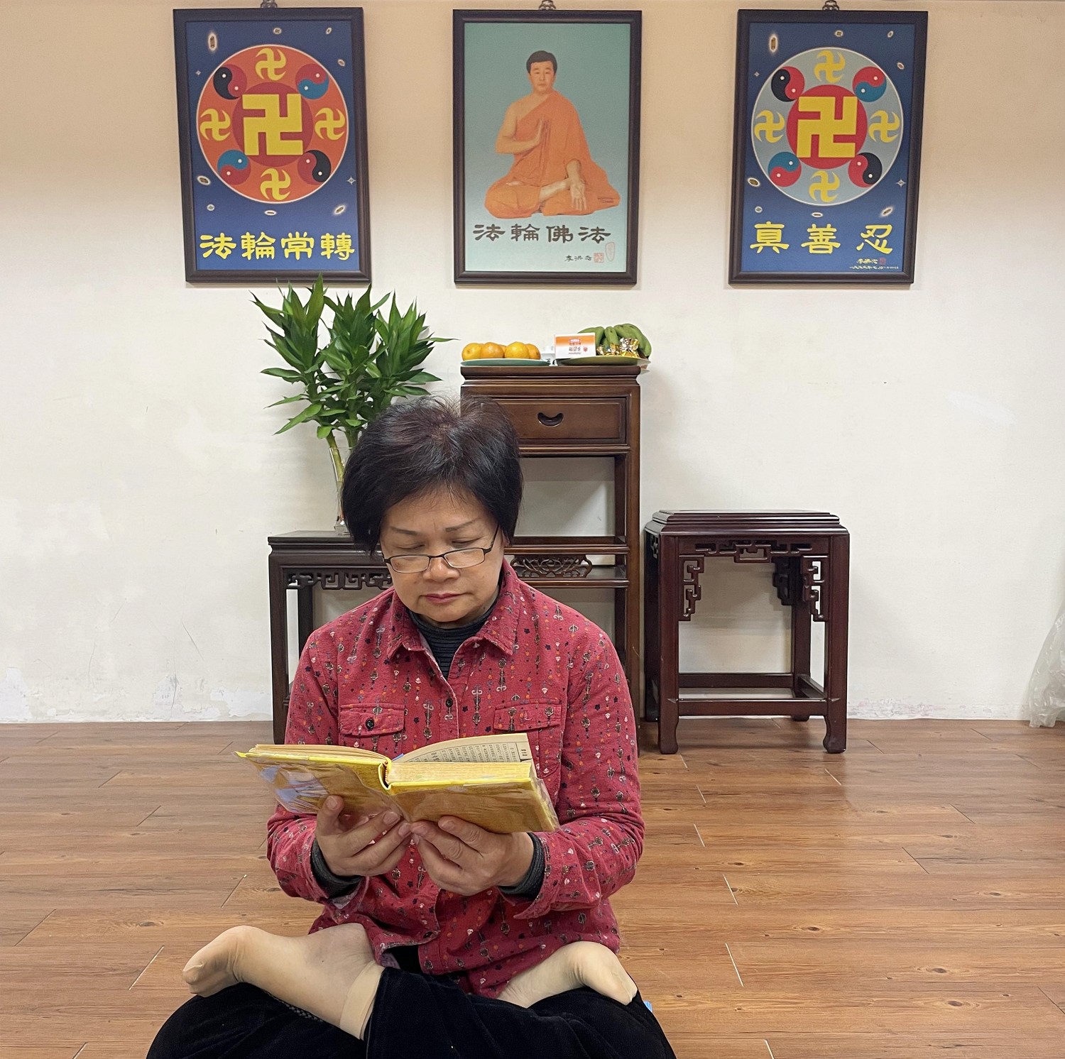 图1:丽美手捧《转法轮》双盘打坐专注阅读着。