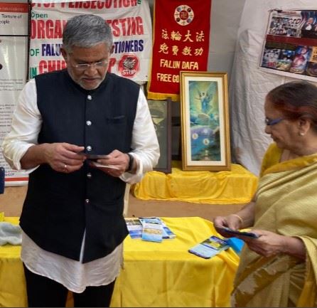 '图4:印度著名演员、编剧和特鲁古电影业导演巴拉尼(Tanikella Bharani)(左)参观了法轮大法展位,了解了法轮大法及其在中国遭受的迫害。'