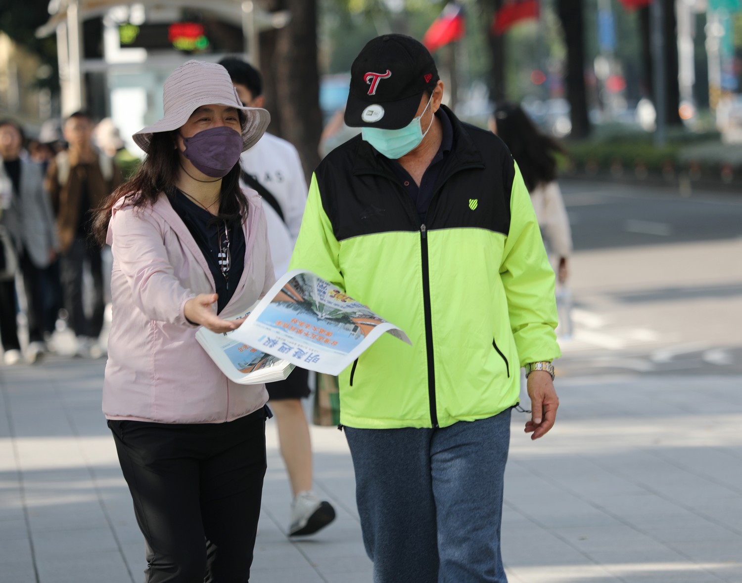 图5~6:法轮功学员向过往民众发送真相资料,分享修炼的美好。