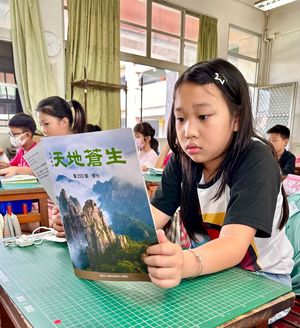 '图8:小菲阅读明慧期刊《天地苍生》'