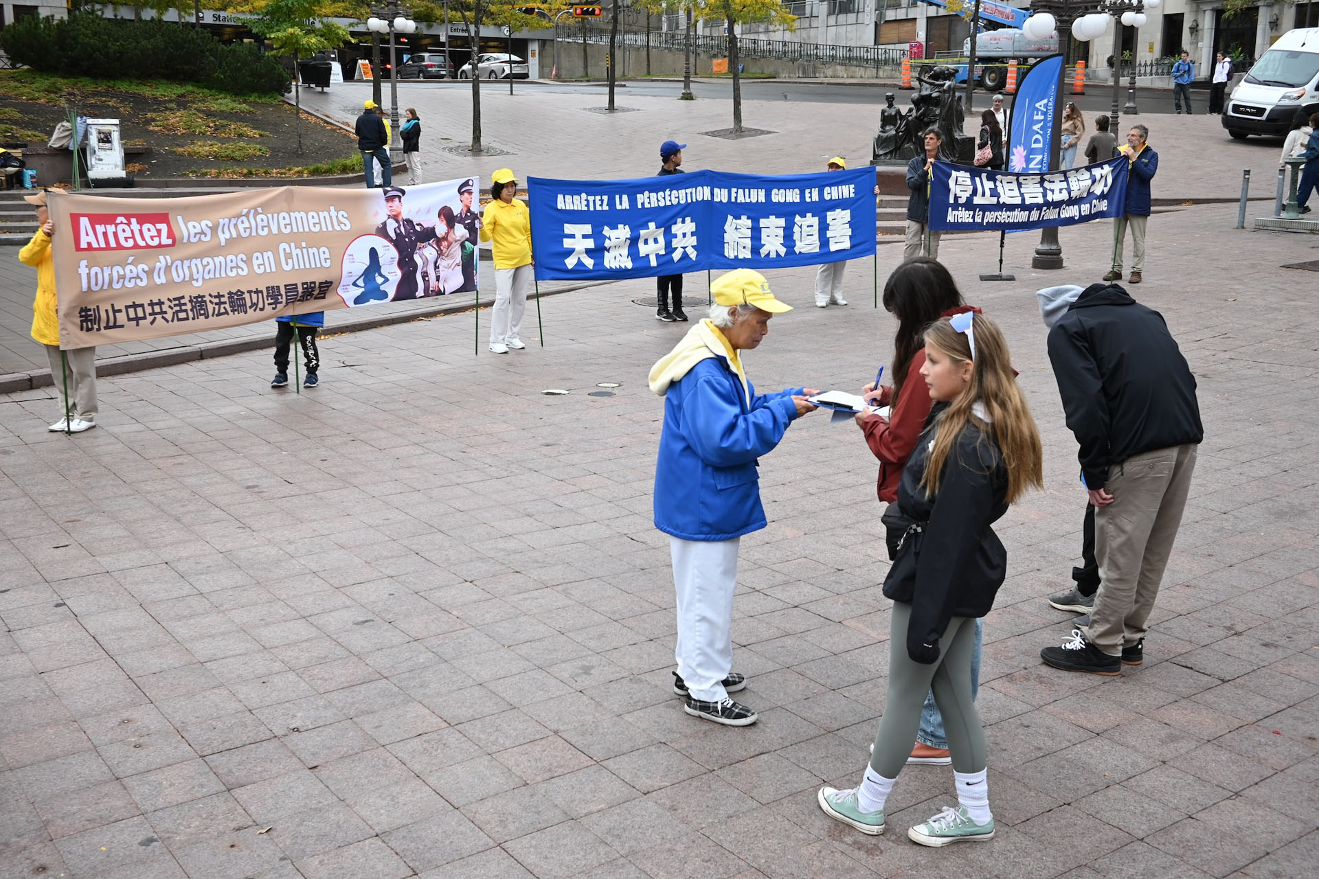 图5~8:人们驻足和法轮功学员交谈并观看活动现场