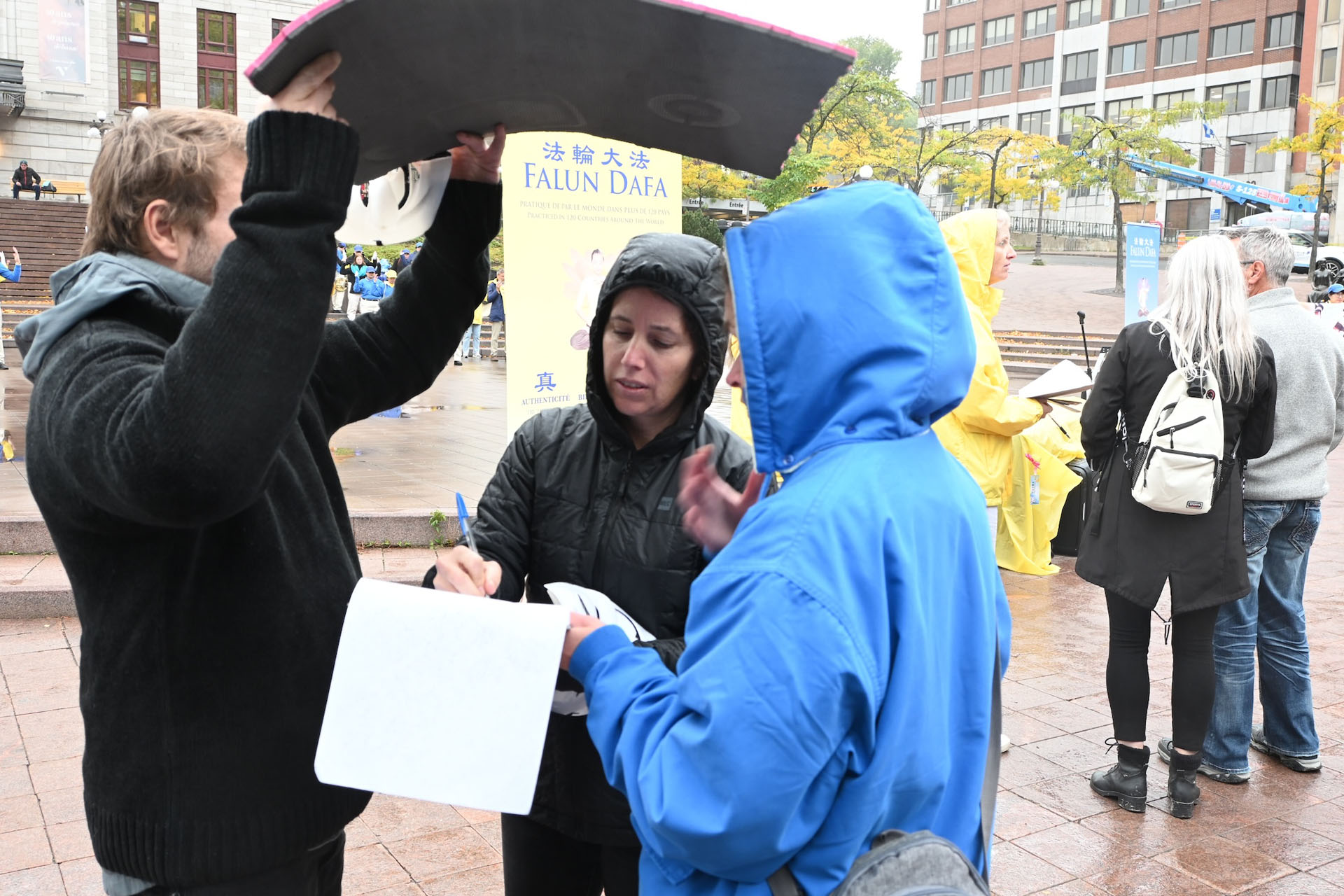 图12:一对女士在细雨中签署请愿书