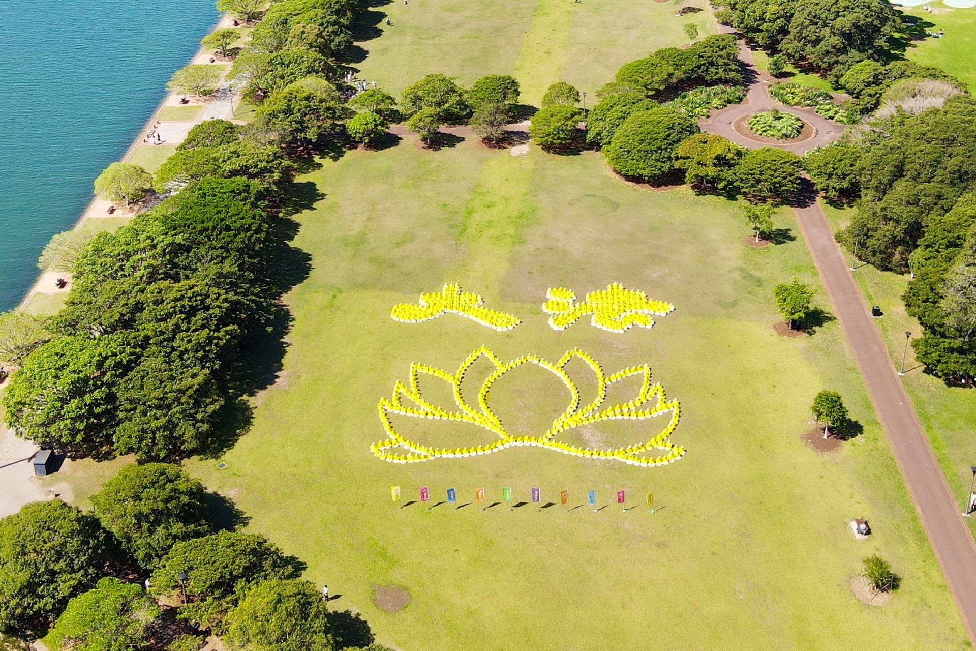 图1~2:二零二四年十月二十六日,在悉尼市中心的银禧水滨公园(Jubilee Park),来自澳洲各地的法轮功学员举行了排字、炼功活动。排出金色隶书体“大法”二字以及美丽的莲花。