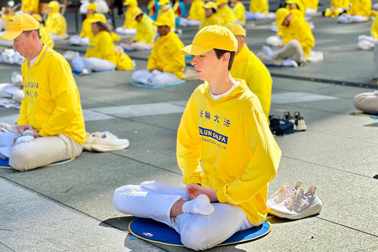 '图1~2:二零二四年十月二十五日清晨,澳大利亚各族裔法轮功学员在悉尼市中心马丁广场(Martin Place)晨炼,展示舒缓优美的五套功法。'
