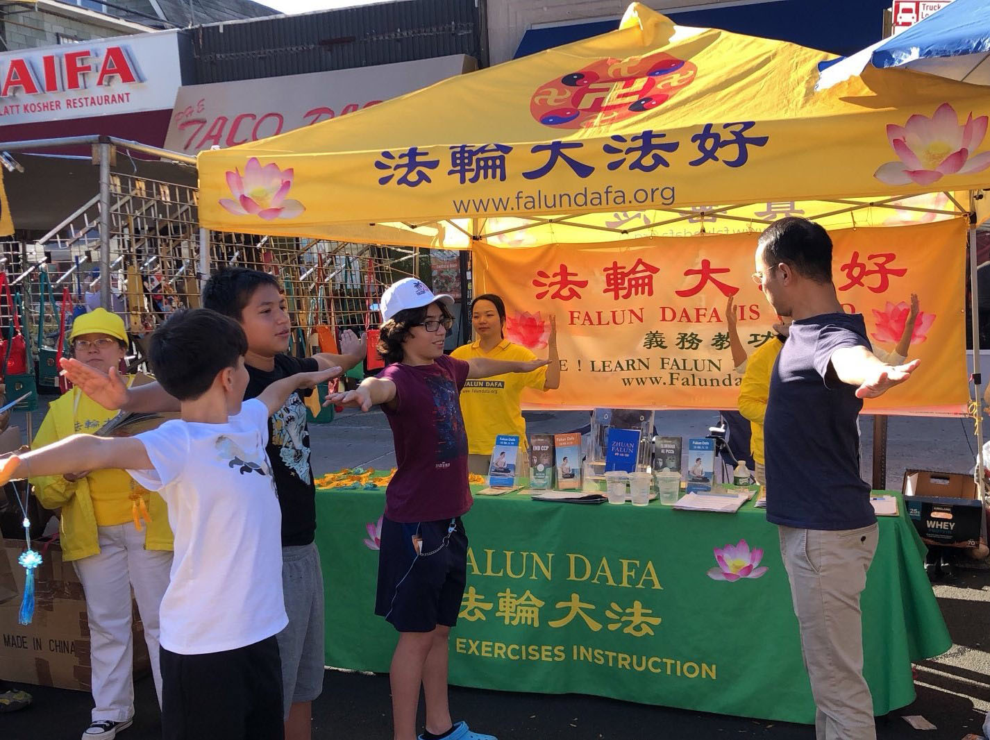 图5~7:不少有缘人被法轮功的纯正能量吸引,自然汇聚到法轮功展位现场学炼法轮功。