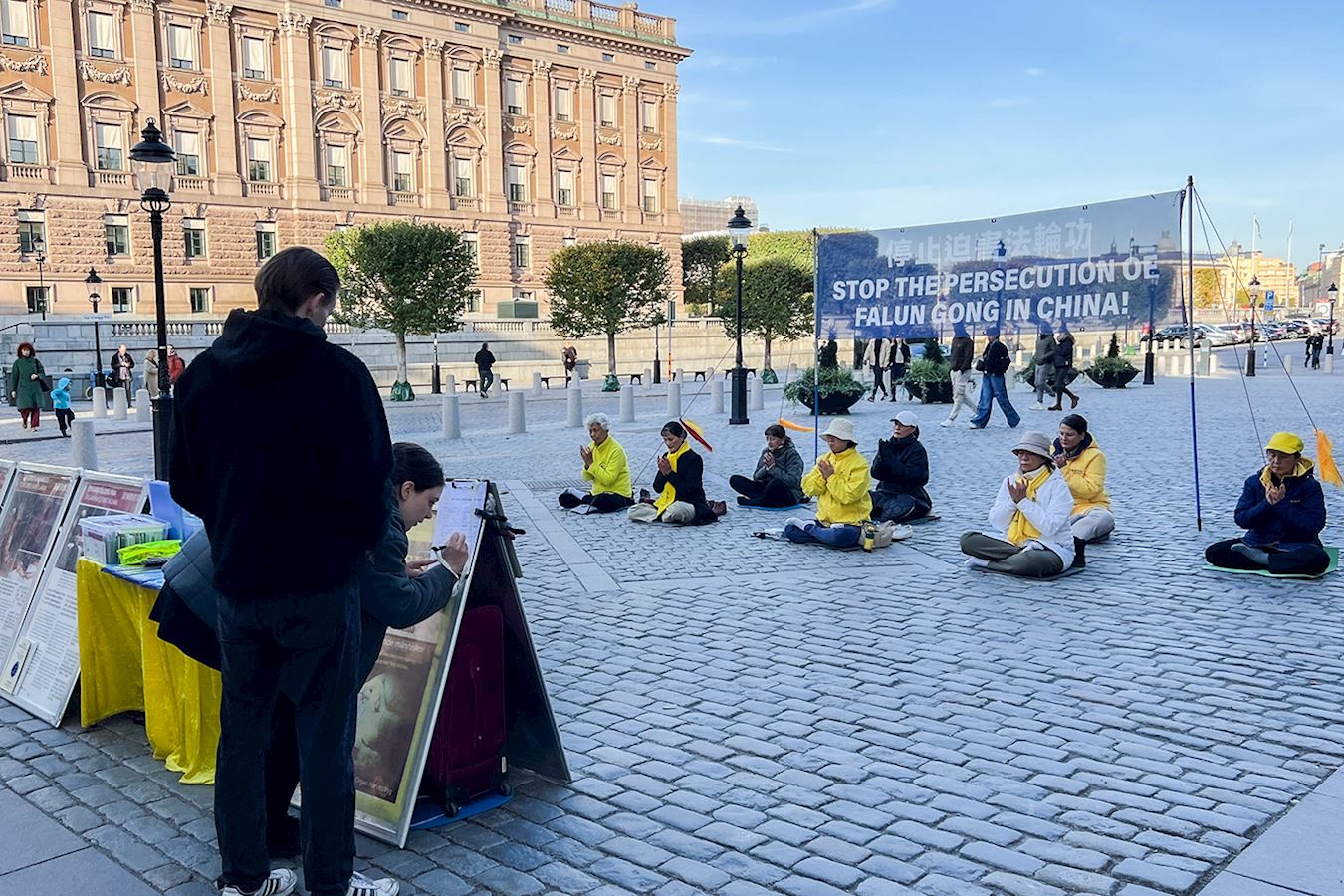 '图1~4:二零二四年十月份的每个周五、周六下午,法轮功学员都在瑞典国会大厦旁的钱币广场,向民众介绍法轮功、演示功法,揭露中共迫害。'