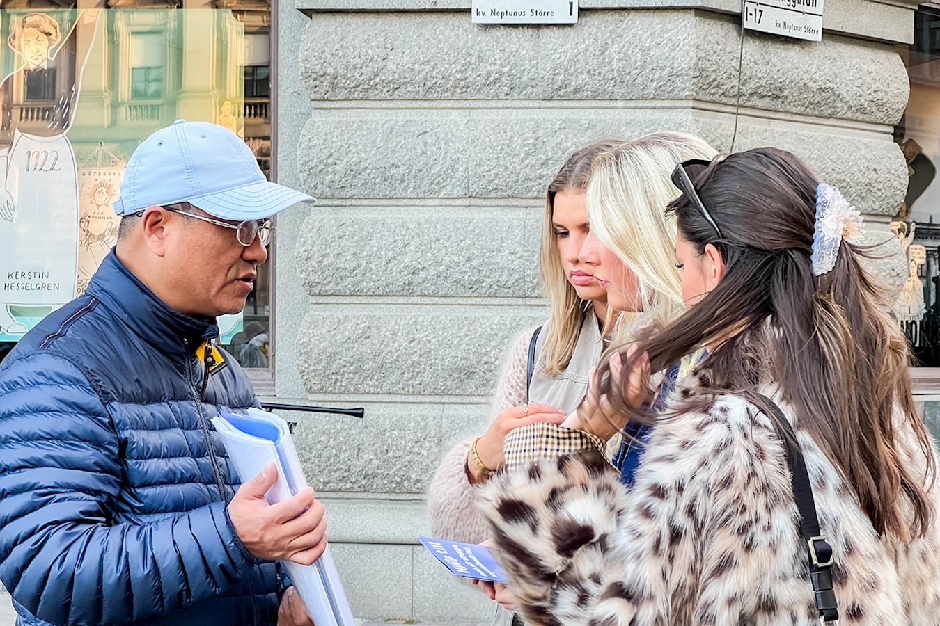 '图5~8:法轮功学员在瑞典国会大厦旁举办的真相活动中,面对面向当地民众及游客介绍法轮功、讲述法轮功真相。'