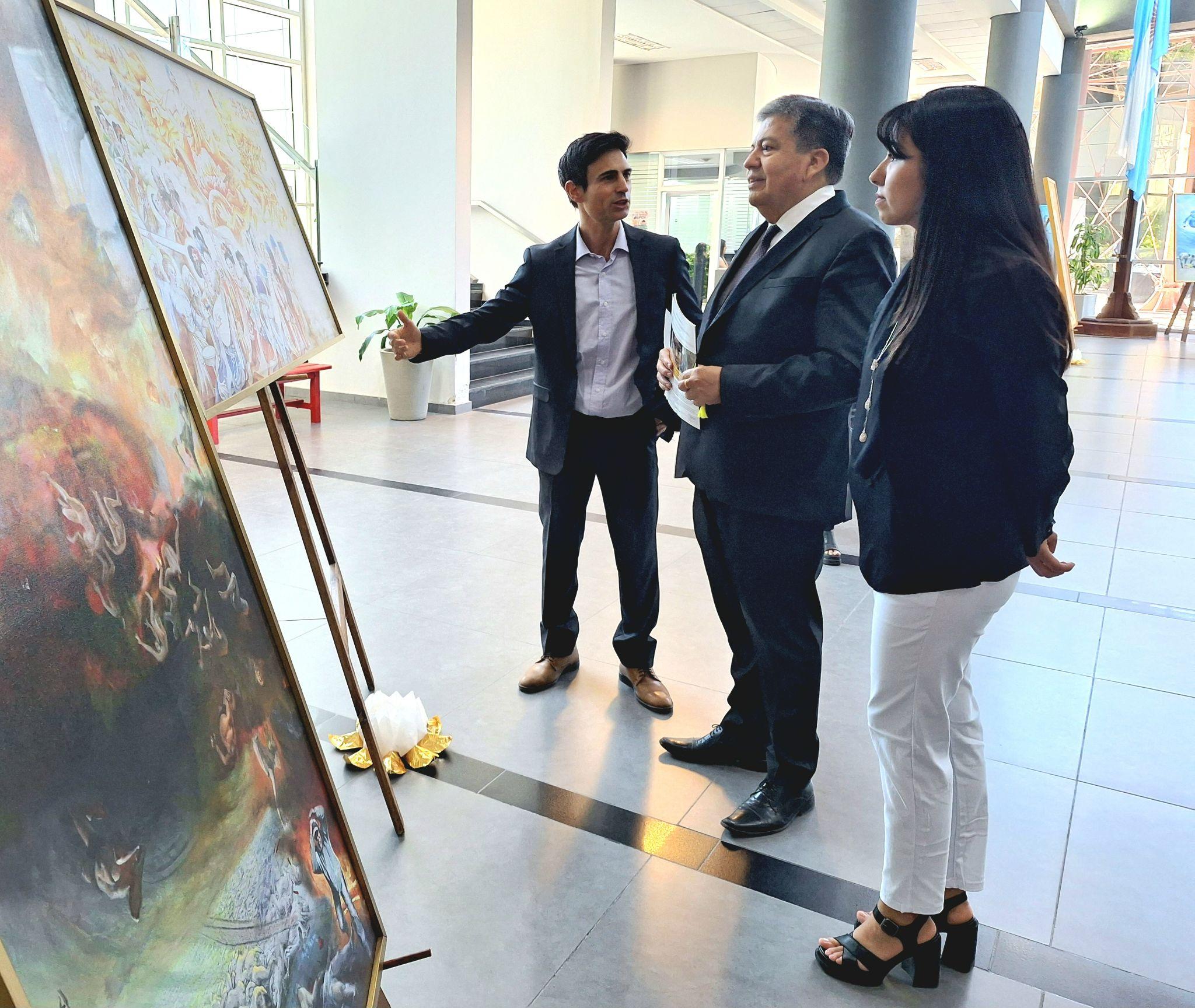 图4:圣地亚哥-德尔埃斯特罗国立大学校长(图中)观看真善忍美展画作。