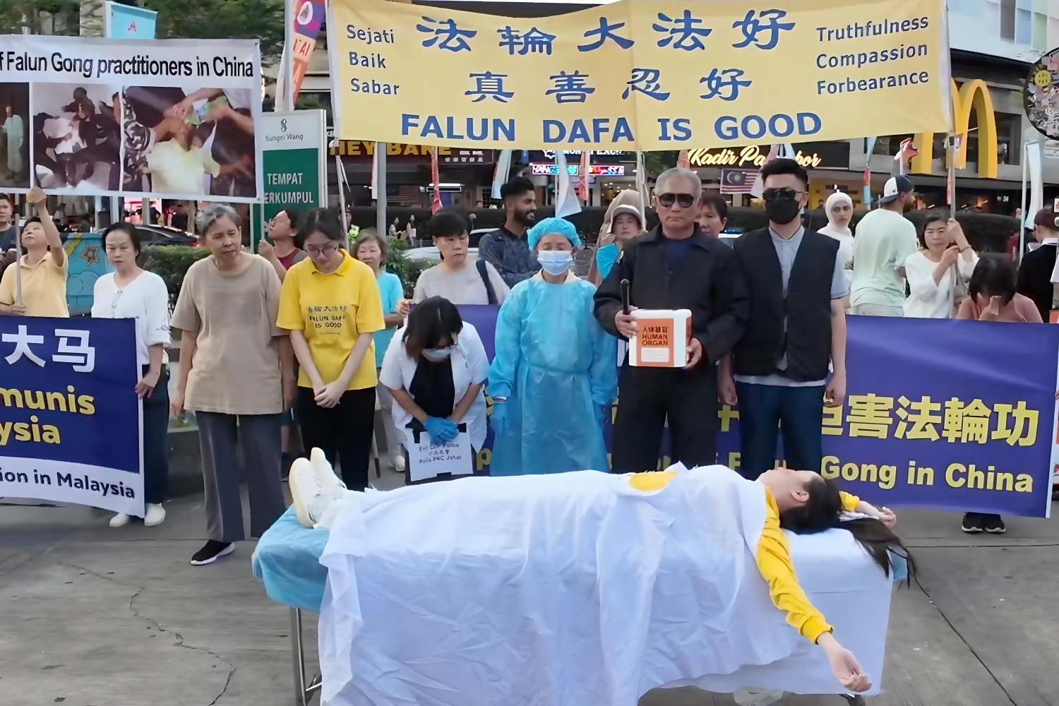 图6:2024年12月7日,马来西亚部份法轮功学员来到首都吉隆坡市中心武吉免登繁忙地段举行反迫害集会与中共活摘法轮功学员器官模拟表演。