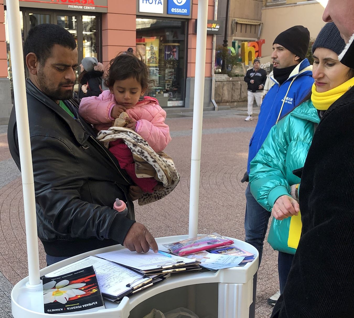 '图5:一名男子表示支持中国的法轮功学员,并在请愿书上签名。'