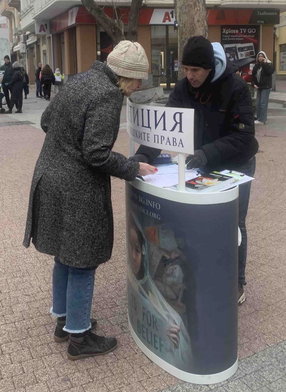 '图7:万尼亚(左)在请愿书上签名,并祝法轮功学员成功。'