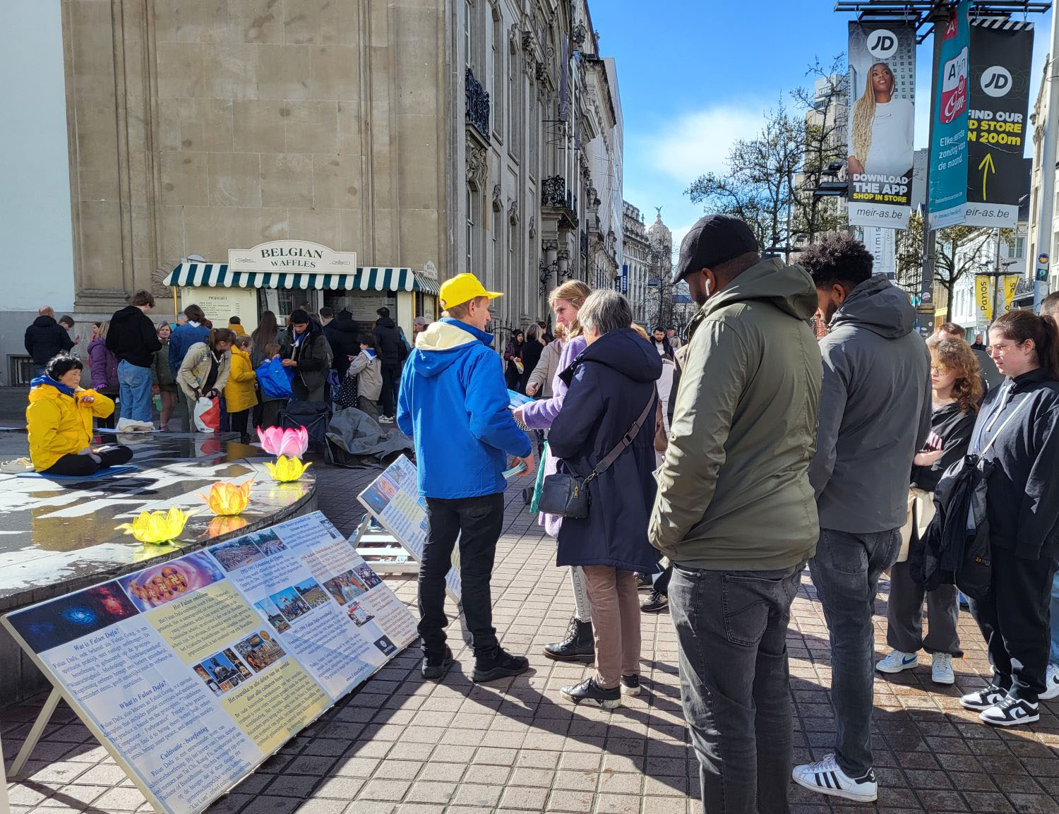 图1~2:二零二四年三月二十三日,法轮功学员在安特卫普(Antwerpen)商业街举办弘法讲真相活动。学员在向市民及游客展示功法。